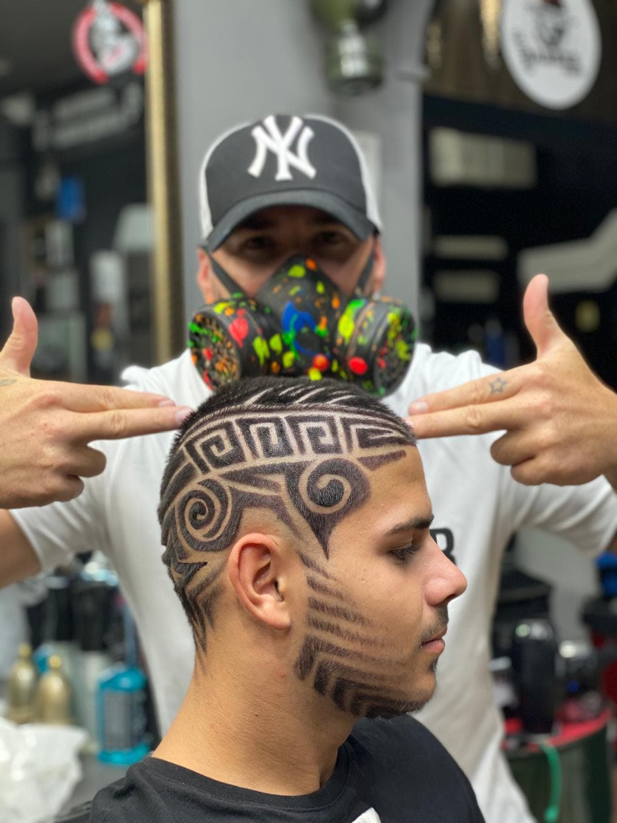Frizer cu mască de vopsit și șapcă NY pozând cu client — design pattern greek ras în fade